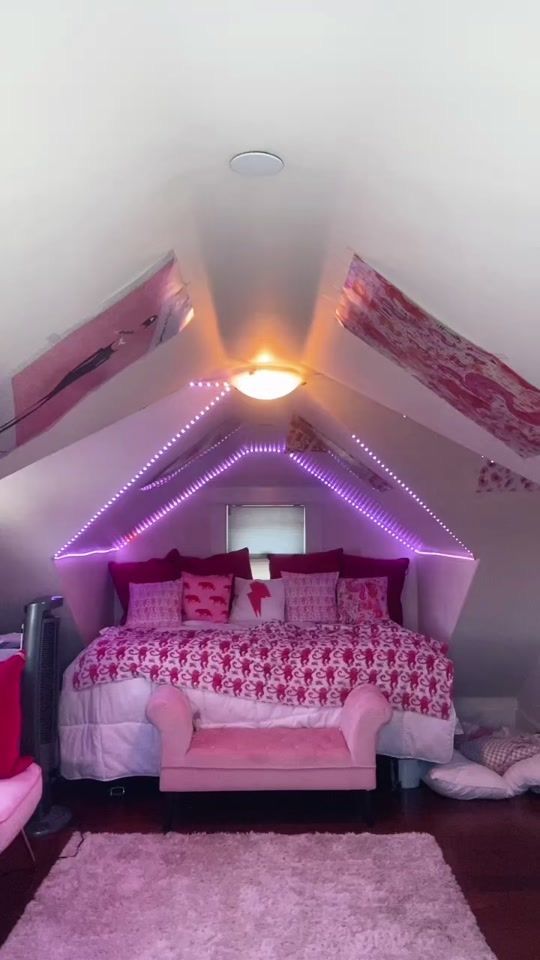 a bedroom with pink bedding and lights on the ceiling is pictured in this image