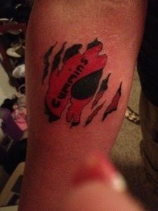 a person with a tattoo on their arm that has an image of a red car