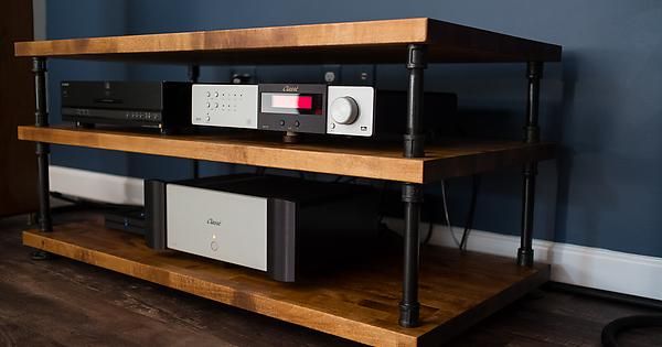 an old stereo system is sitting on a shelf in a room with wood floors and blue walls