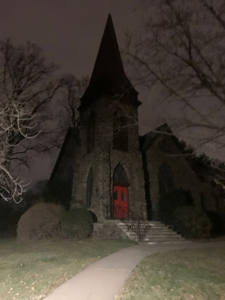 an old church with a red door at night