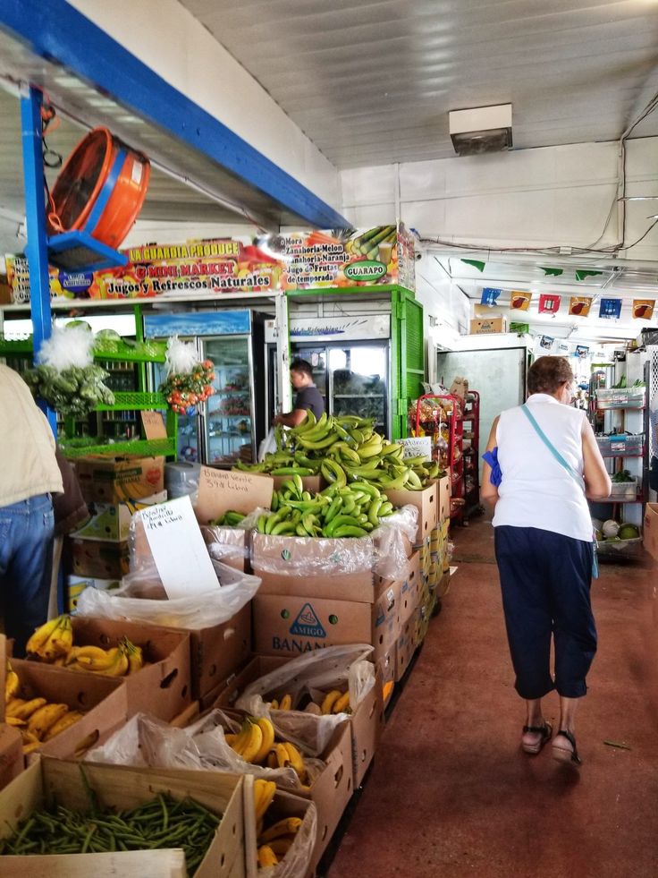 people are shopping at an outdoor market with bananas