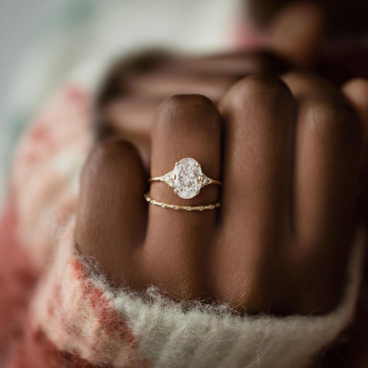 a woman's hand with a diamond ring on it