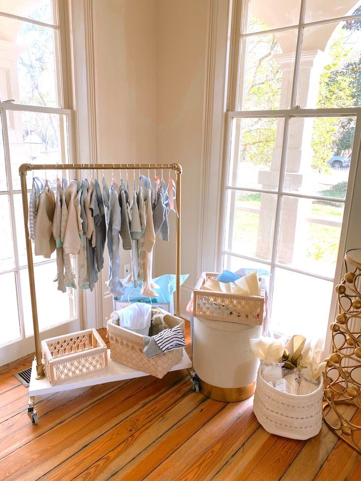 a baby's room with clothes hanging on the rack and other items in baskets