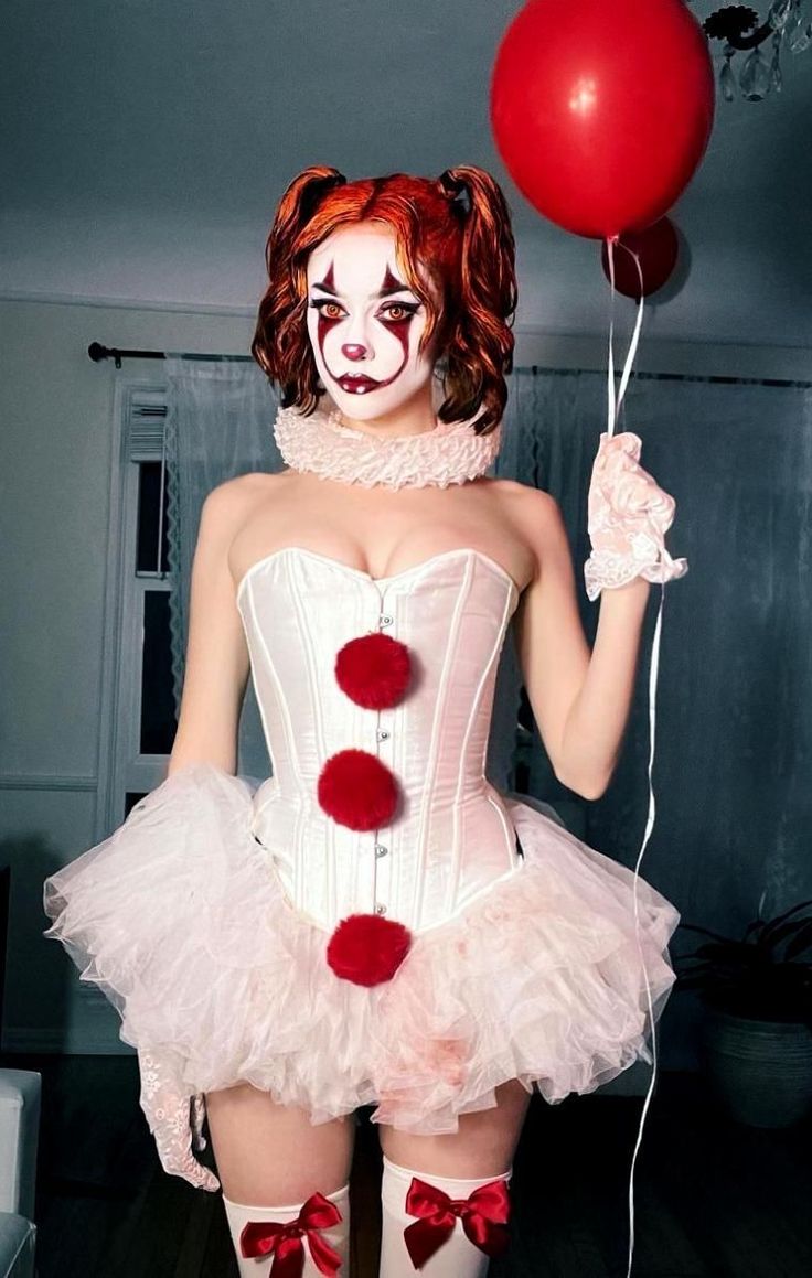 a woman dressed as a clown holding a red balloon