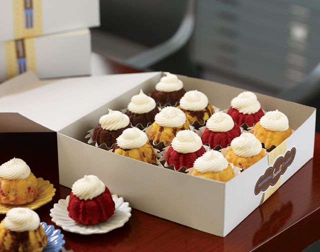 several cupcakes sitting in a box on a table next to some other items