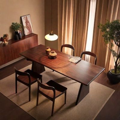 a dining room table with two chairs and a potted plant next to the window