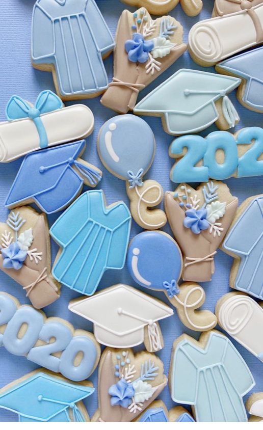 cookies decorated like graduation caps, gowns and mortares are on a blue background