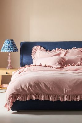 a blue bed with pink sheets and pillows