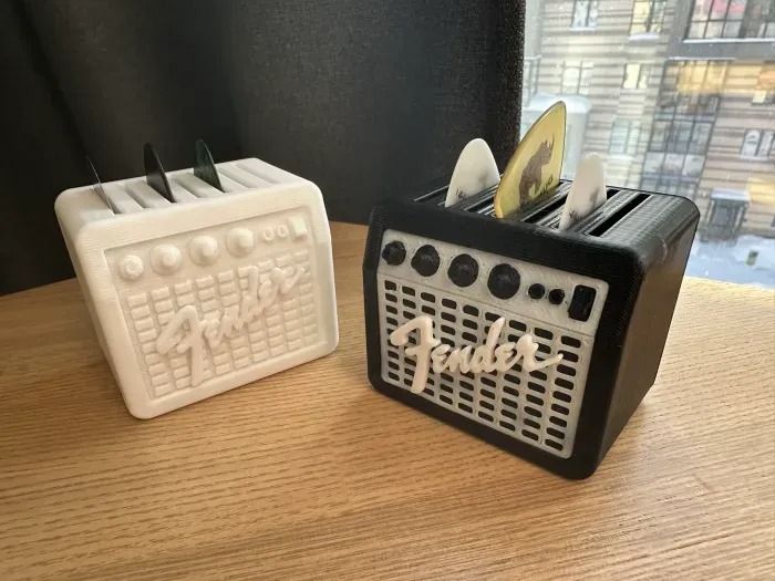 two toasters sitting next to each other on top of a wooden table in front of a window