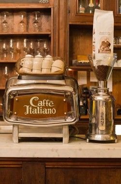 an espresso machine sitting on top of a counter next to a bag of coffee