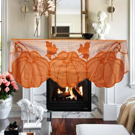 a living room with a fire place in the fireplace and an orange table cloth over it