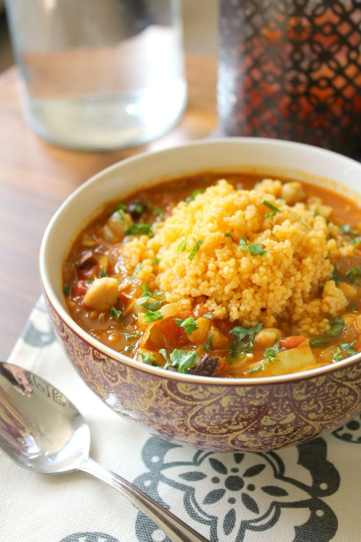 a bowl filled with soup and rice on top of a table