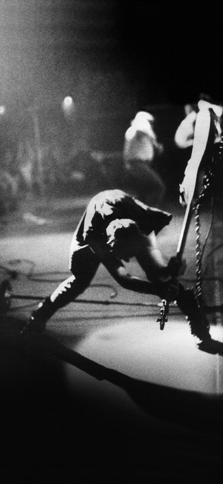 a black and white photo of a person on a stage with a tennis racket