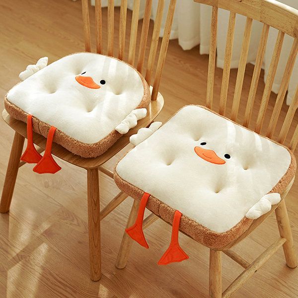 two wooden chairs with cushions on them and one has a ducky seat cushion attached to it