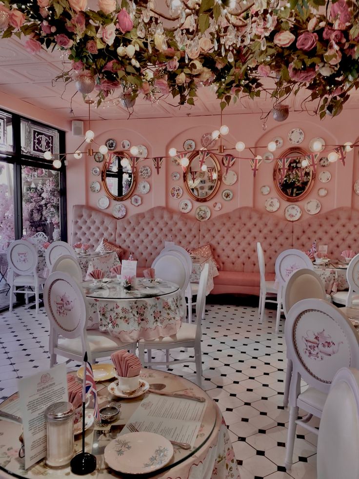 the interior of a fancy restaurant decorated in pink and white