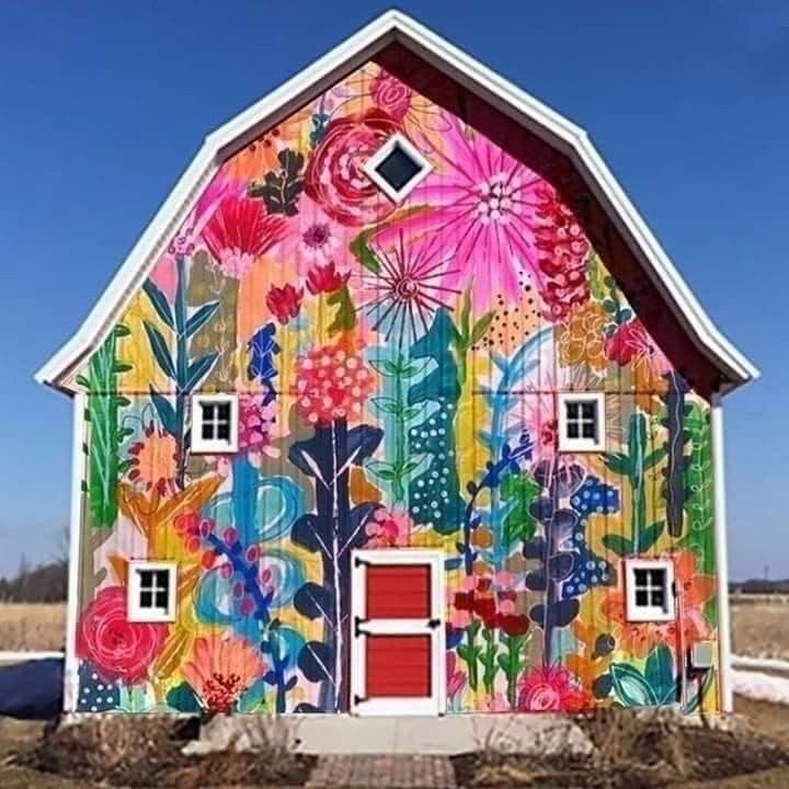 a colorful barn with flowers painted on it