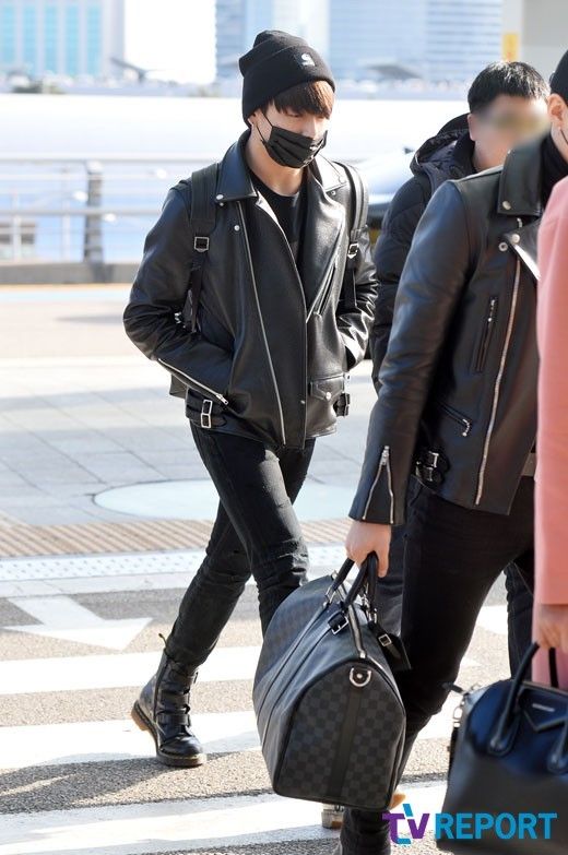 a man wearing a face mask carrying luggage