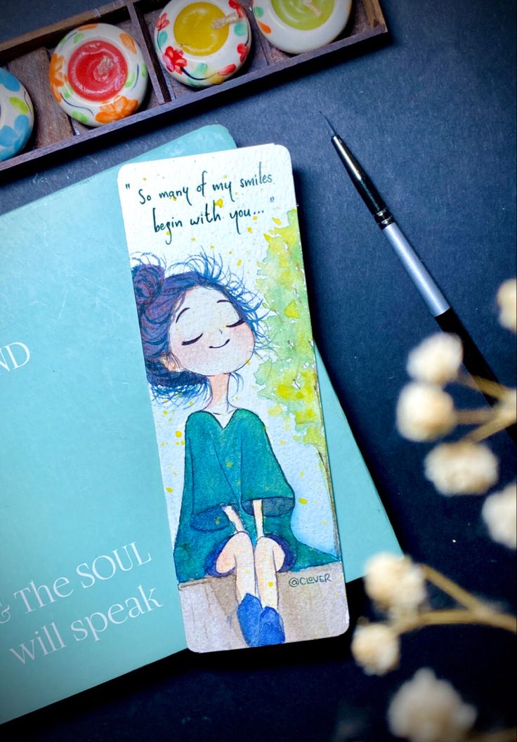 a bookmark with an illustration of a woman sitting on a bench next to some cupcakes