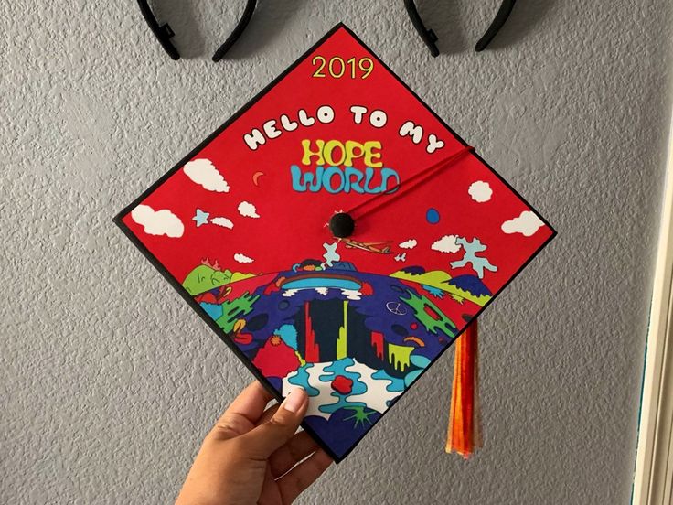 someone holding up a graduation cap that says hello to my hope world