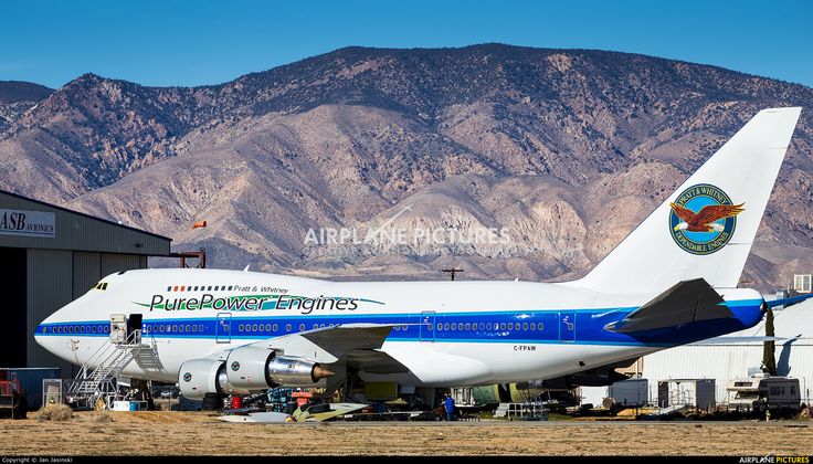 an airplane is parked in front of a mountain