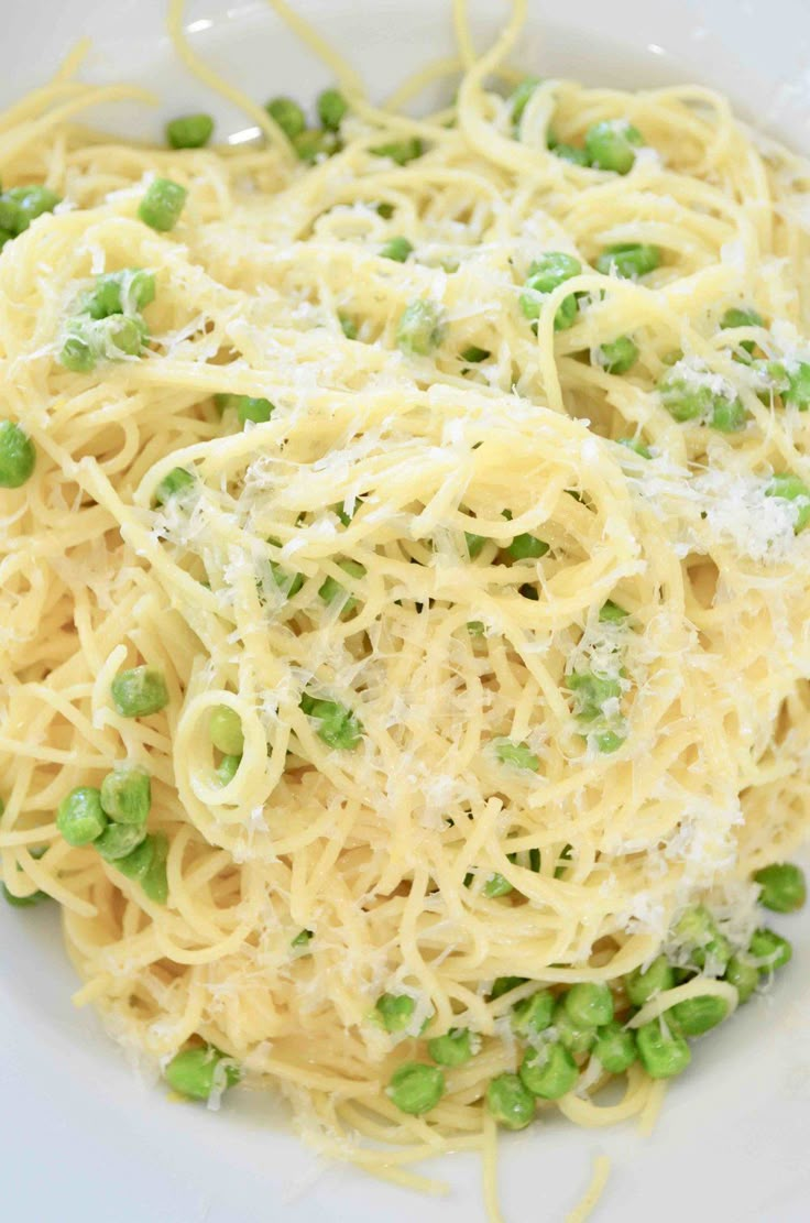 pasta with peas and parmesan cheese in a white bowl