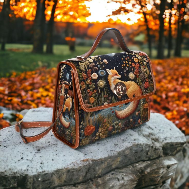 "Forestcore Fox and Flowers Cottage Witch Satchel Bag. This purse features a 3D Effect Faux-Embroidery image. It is not actually embroidery. Fashioned from durable waterproof canvas and vegan leather straps, this gorgeous cottagecore crossbody bag is just what you need for a little extra room for all of your essentials. Made from high quality materials, this cottagecore style boho bag features a secure magnetic snap closure and adjustable shoulder strap. Can be used as a nice iPad storage bag, b Cottage Core Purse, Fantasy Satchel Leather Bags, Dark Forestcore, Cottagecore Items, Cottagecore Purse, Forest Fairy Bag, Fox And Flowers, Witch Cottagecore, Witch Bag