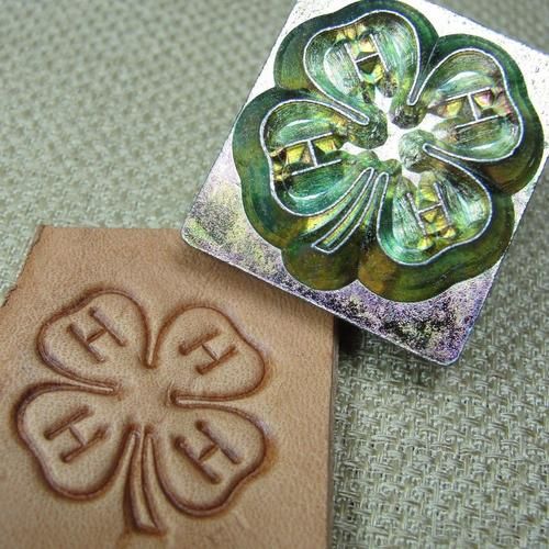 two rubber stamps with designs on them sitting next to each other, one has a four leaf clover