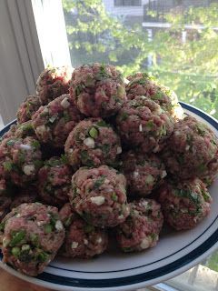 a white plate topped with meatballs next to a window