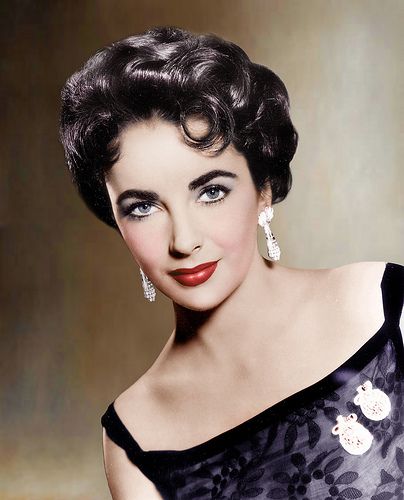 an old photo of a woman in a black dress with large earrings on her head