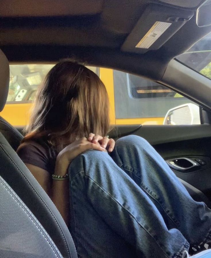 a woman sitting in the back seat of a car