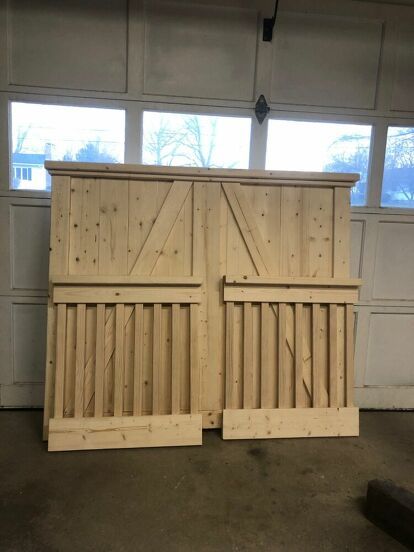 two wooden doors sitting next to each other in front of a garage door with windows