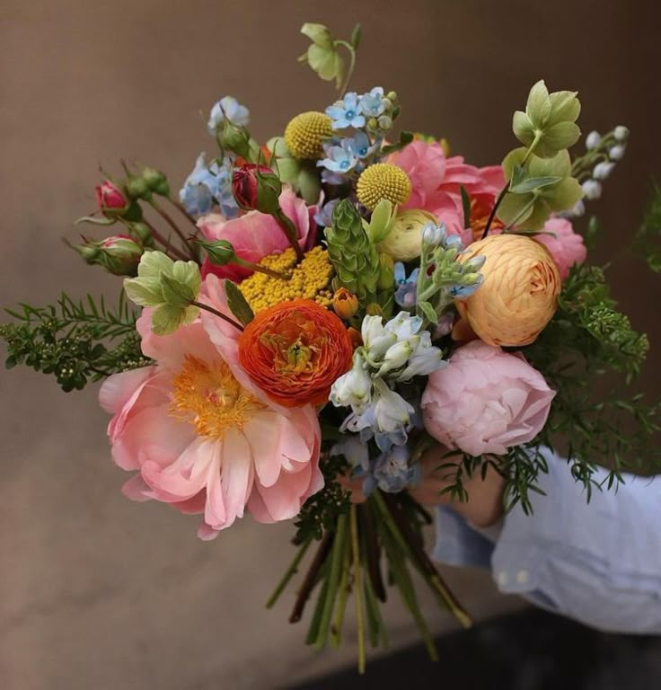 a person holding a bouquet of flowers in their hands