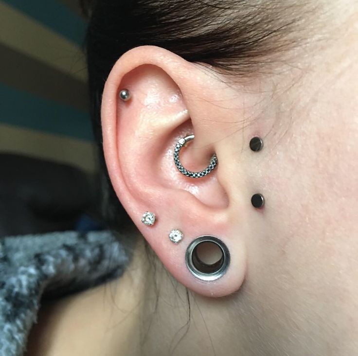 a woman with three piercings on her ear