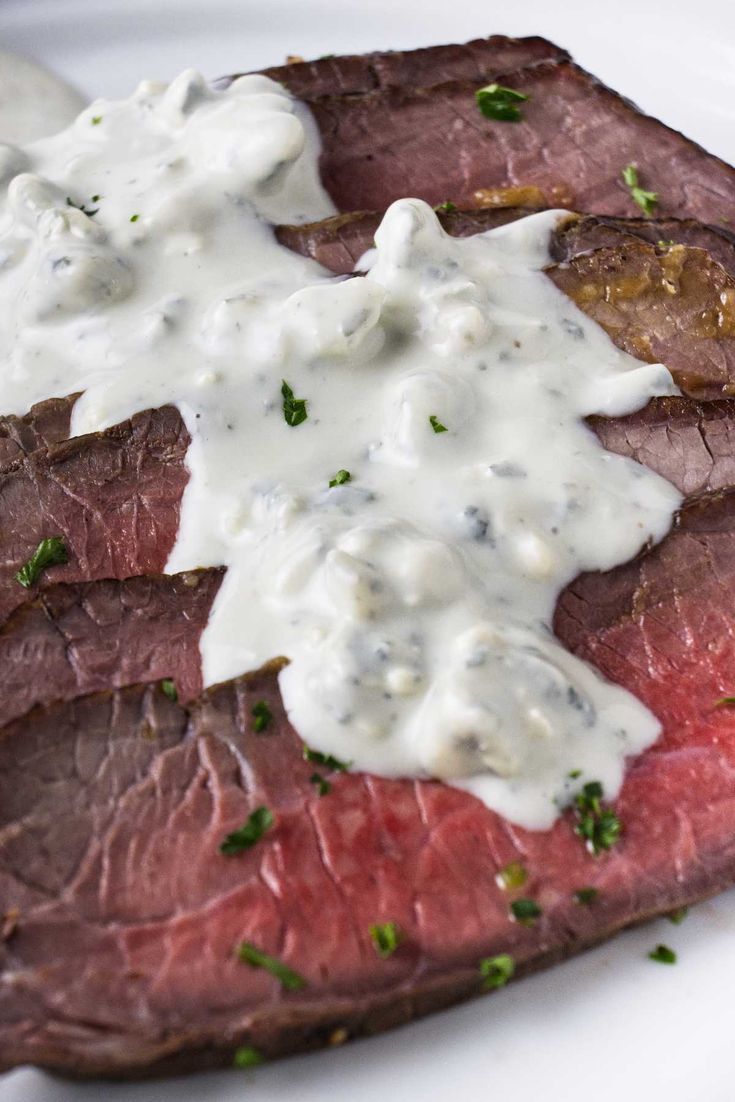 steak with white sauce and parsley on top