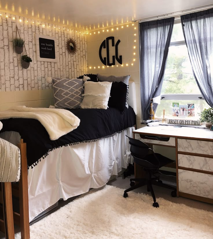 a dorm room with lights strung on the wall and a desk in front of it