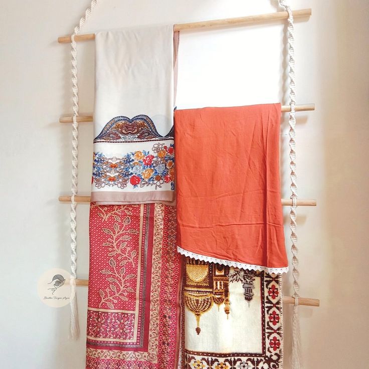 three towels hanging up on a wooden rack