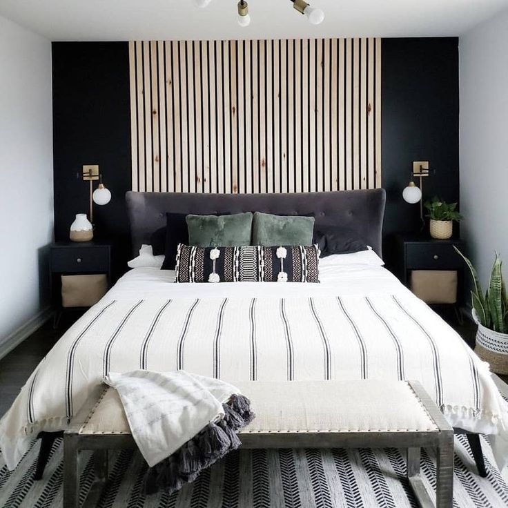 a black and white bedroom with striped bedding, potted plants and decorative wallpaper