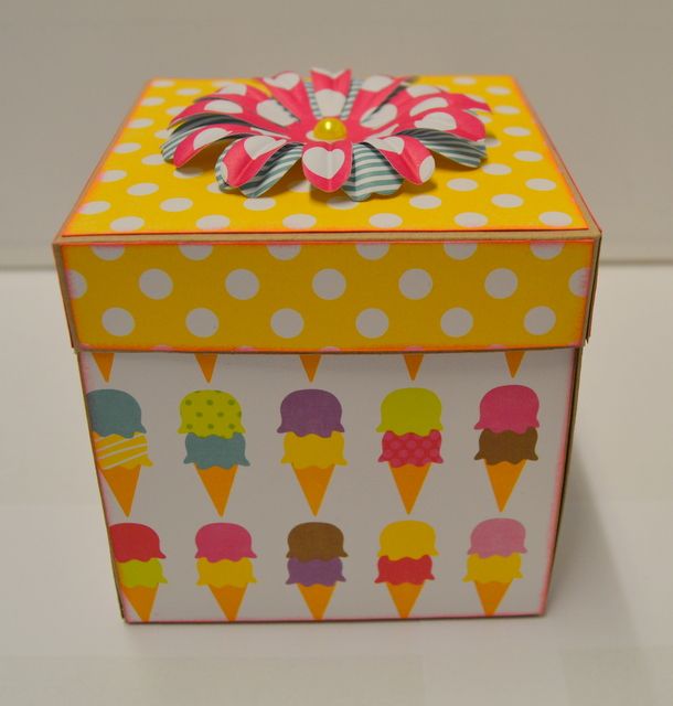 an ice cream box is decorated with polka dots and a flower on the top,