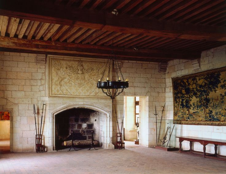 a large room with a fireplace and paintings on the wall