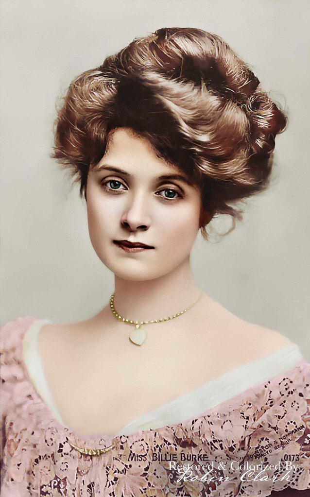 an old fashion photo of a woman wearing a pink dress with her hair in a bun