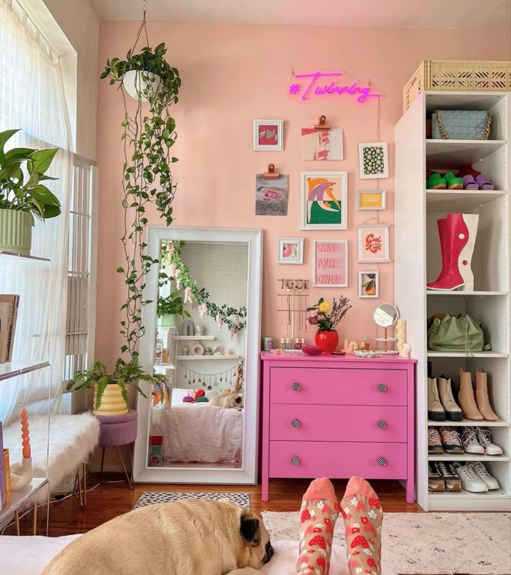 a dog laying on top of a bed next to a pink dresser