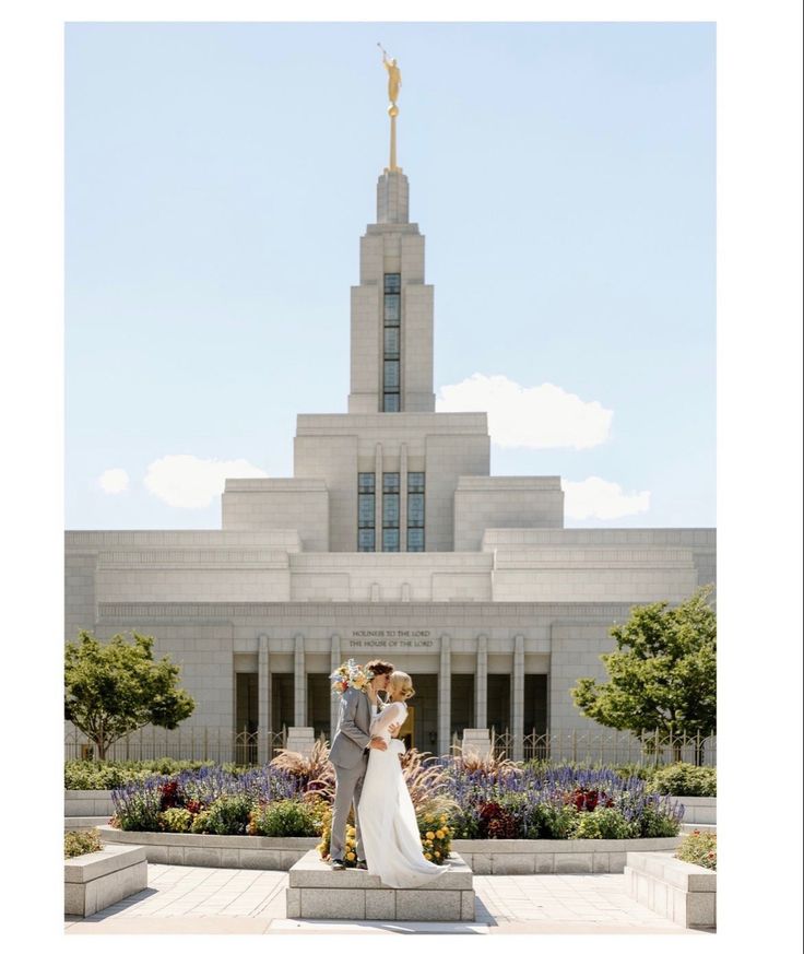 a bride and groom standing in front of the mormon temple