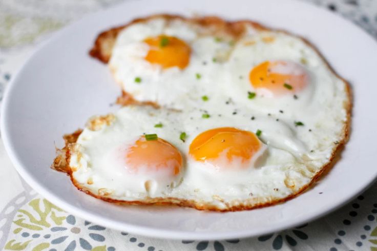 two fried eggs are on top of bread