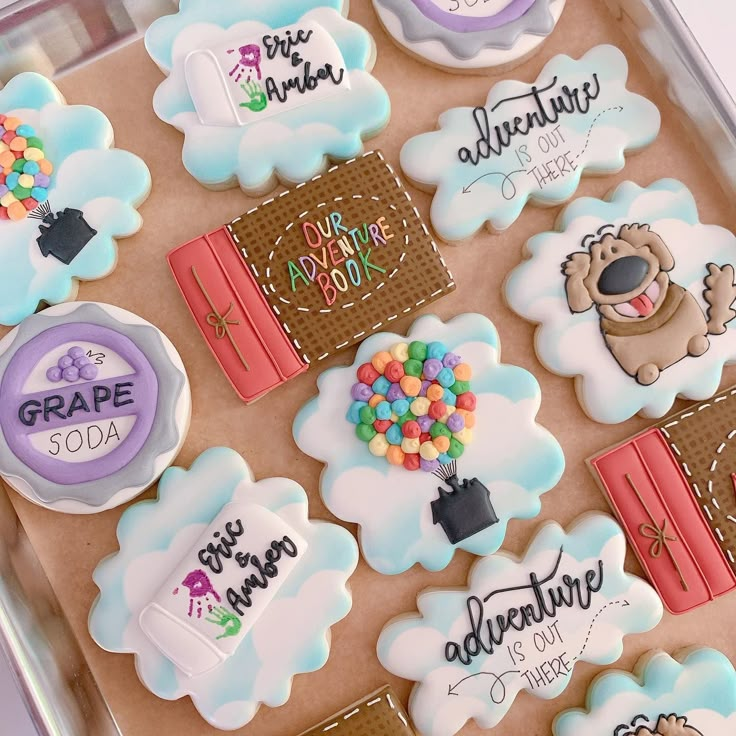 decorated cookies in the shape of clouds with words and pictures on them that say adventure