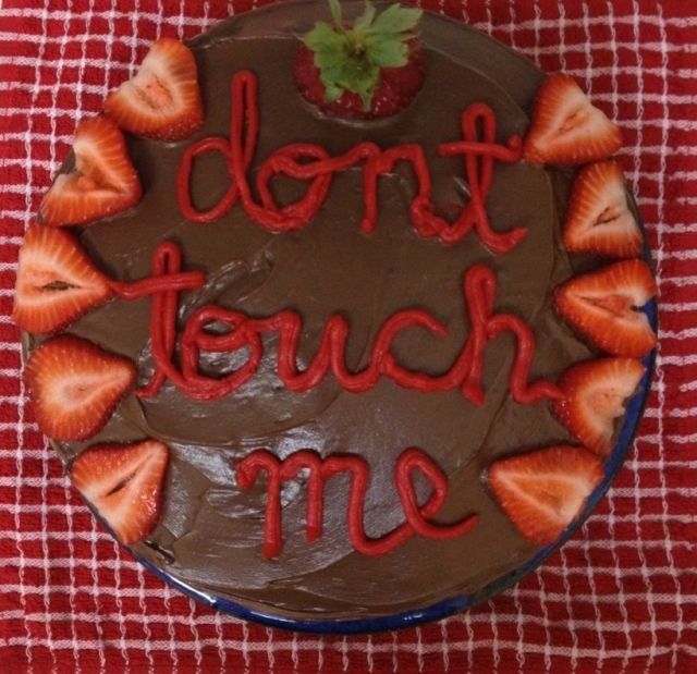 a chocolate cake with strawberries and the words don't touch me written on it