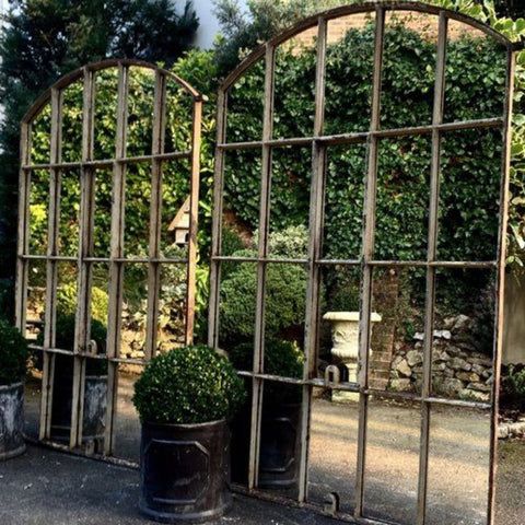 an outdoor area with potted plants and mirrors