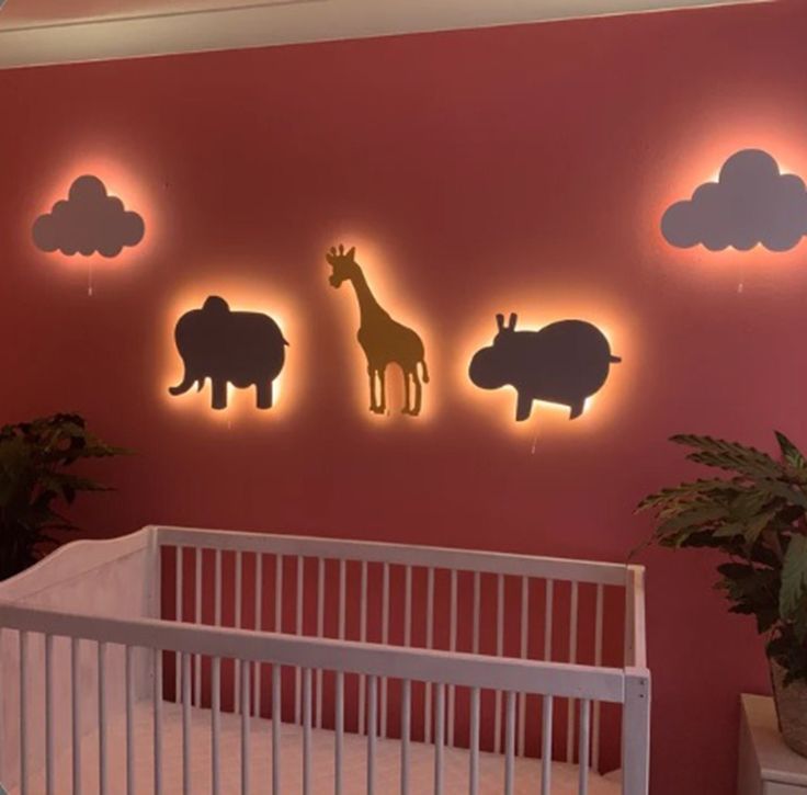 a baby's room with pink walls and animals on the wall