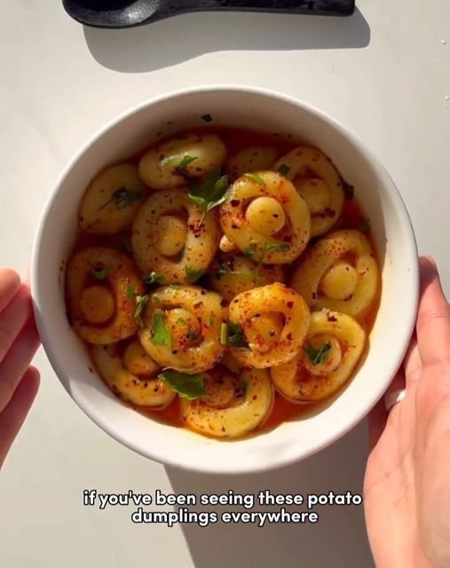 a person holding a white bowl filled with food