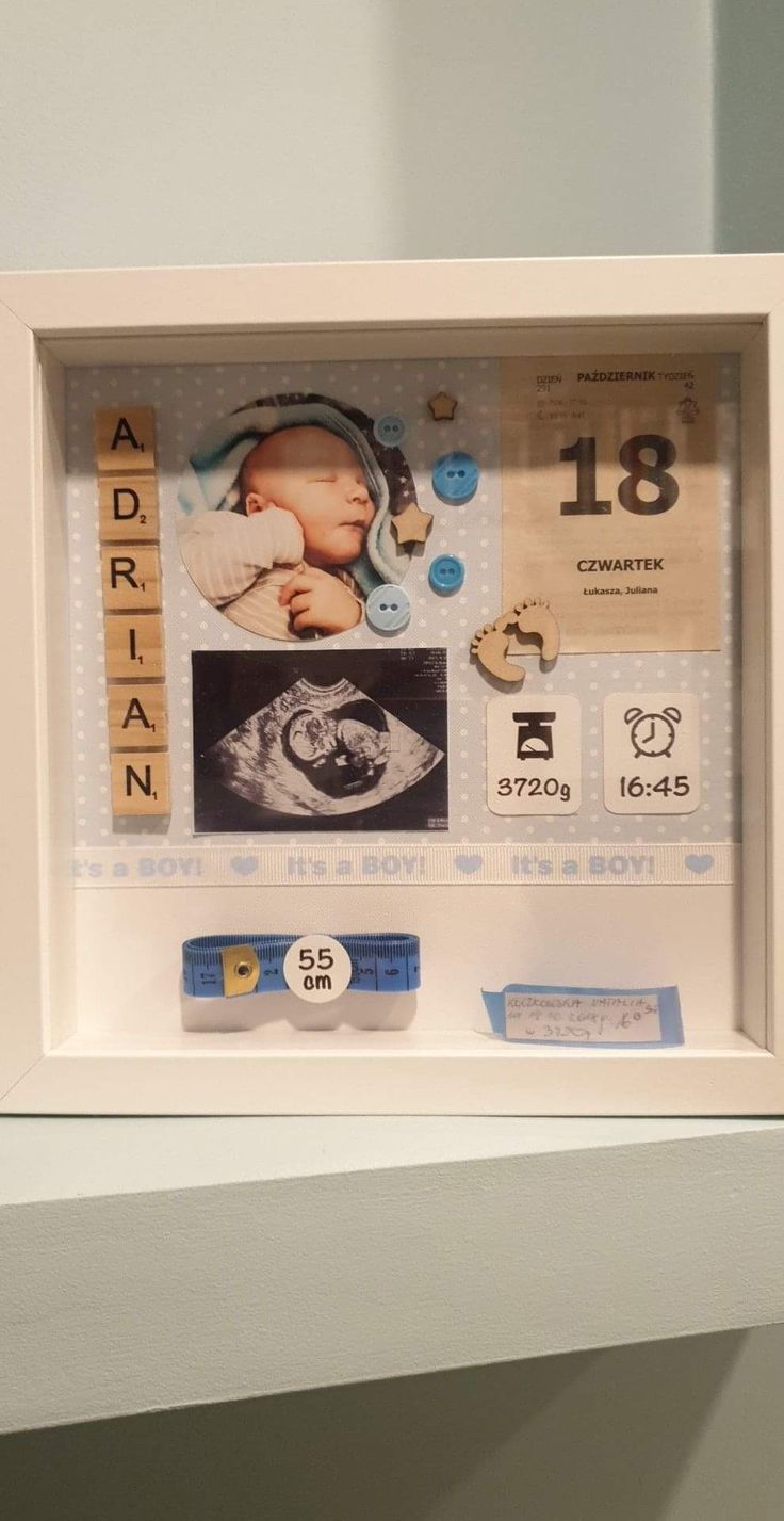 a baby's birth announcement is framed in a white frame with buttons and magnets