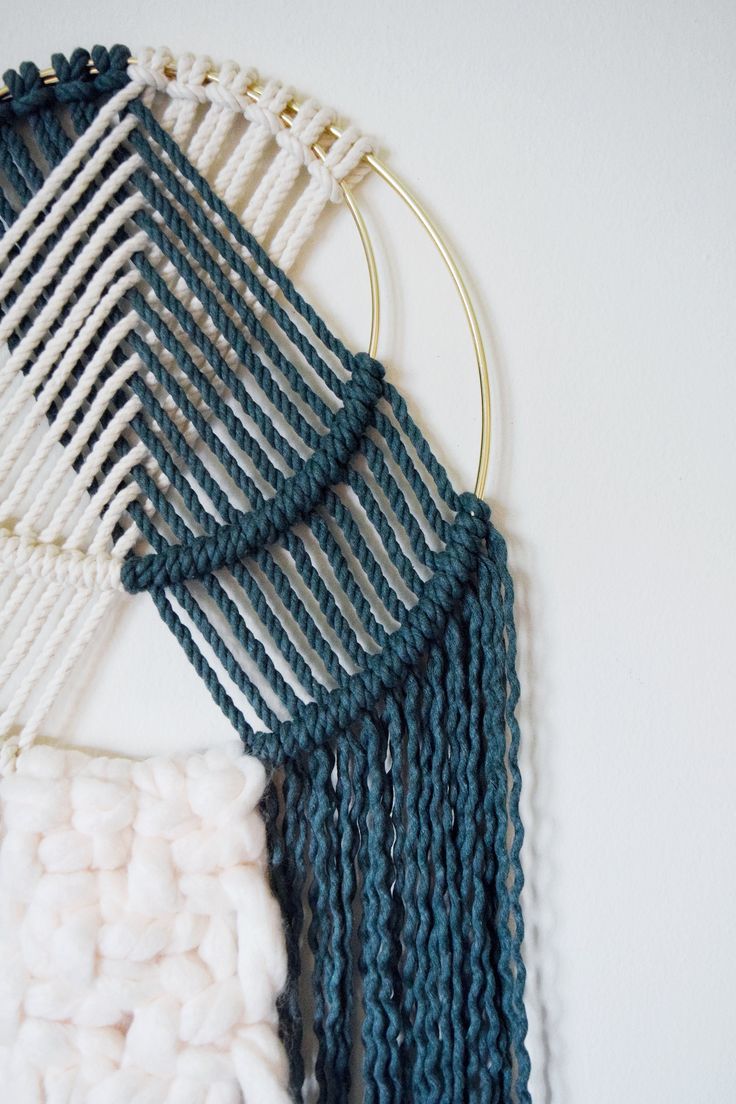 a close up of a wall hanging with yarn